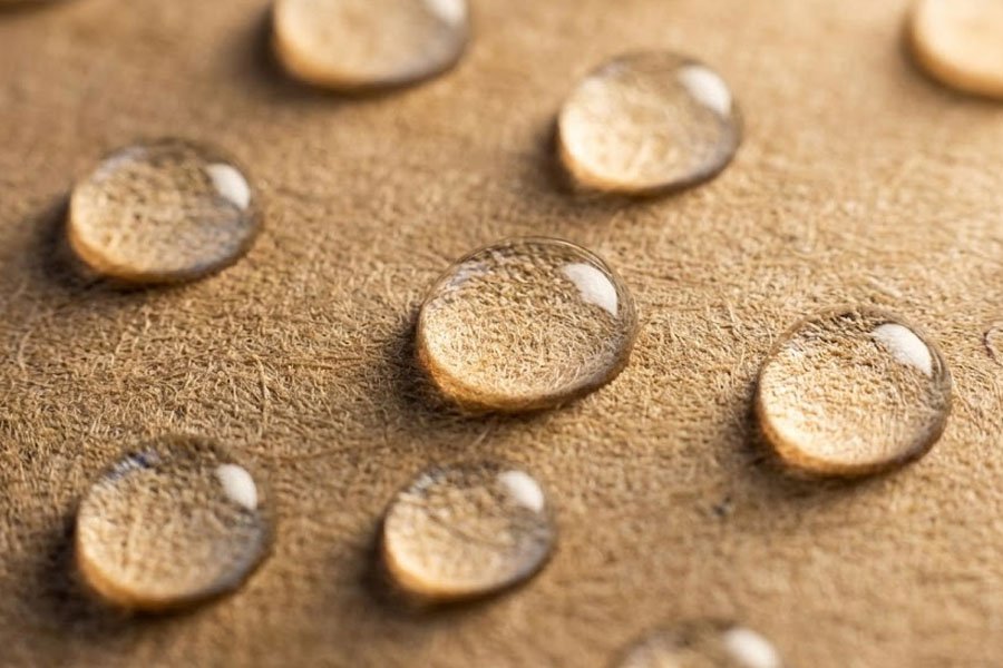 krople wody spoczywające na powierzchni brązowego papieru typu kraft